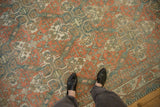Low-pile texture and geometric lattice design on a distressed Caucasian carpet viewed from overhead.