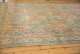 Low angle view of a vintage Caucasian carpet, highlighting the distressed texture of its lattice pattern.