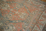 Low pile on a vintage Caucasian carpet with geometric patterns in cantaloupe, sand, and dusty blue.