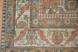 Detail of the roundel palmette and serrated vine border on a vintage Caucasian carpet.
