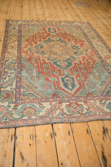Distressed, low-pile texture of a vintage Baktiari rug with its geometric red, blue, and ivory pattern.
