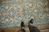 A personal, top-down view of the distressed weave and dragon motifs on a vintage Malayer rug.