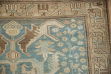 Vintage Persian Malayer rug corner with stylized birds on a sky blue field and geometric sand border.