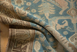 Folded vintage Malayer rug showing its supple hand-knotted texture in sky blue and sand tones.