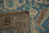 A folded corner of the distressed Persian rug displays its hand-knotted foundation and worn pile.