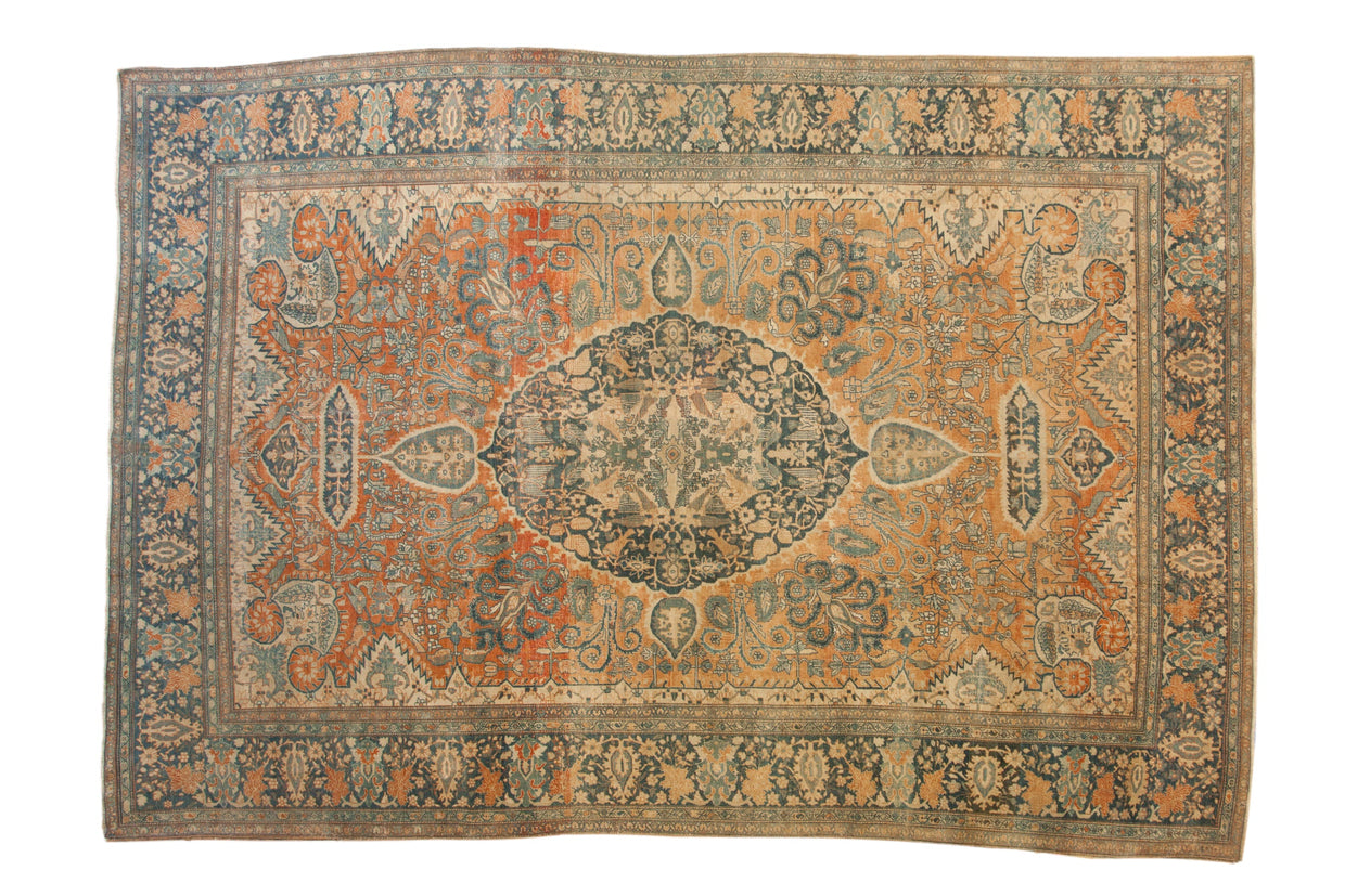 Antique Farahan Sarouk carpet with a scalloped center medallion on a rust field of blossoms and scrolled vines.