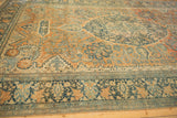 Angled perspective of a Farahan Sarouk carpet revealing its time-softened pile and wide floral border.