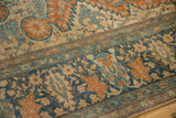Low-pile texture and even wear on the detailed floral border of an antique Farahan Sarouk carpet.