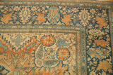 Corner detail of an antique Farahan Sarouk carpet showing floral borders with a worn, low pile texture.