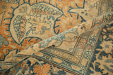 A rolled section of an antique Farahan Sarouk rug highlights its even wear and detailed weave in terracotta and dusty blue.
