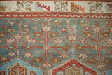 The serrated leaf border and worn, hand-knotted pile of a vintage Baktiari carpet.