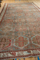 A long perspective view of a distressed Baktiari carpet showing its repeating hexagonal pattern.