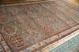Repeating hexagonal panels in slate blue and red on a distressed vintage Bakhtiari carpet.