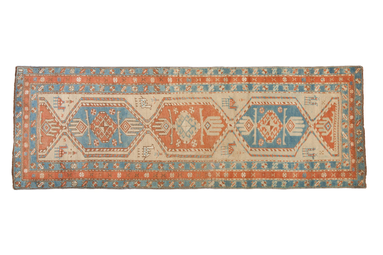 Antique Persian Serab runner with three interconnected medallions and animal motifs in sky blue, madder red, and beige.