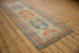 Angled perspective of an antique Serab runner with red and blue interconnected medallions.