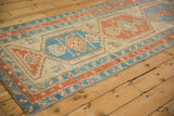 A distressed antique Serab runner seen from an angle, highlighting its interconnected medallion design.