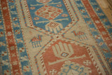 Stylized camel motif and visible knot heads on a sand-colored antique Serab rug runner.