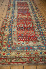 Angled view of an antique Karabagh runner highlighting its staggered boteh field and tiered borders.
