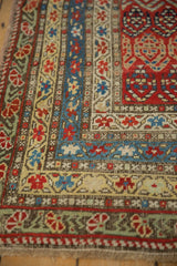 Corner detail of an antique Karabagh rug showing its tiered floral, vine, and cross-hatch borders.