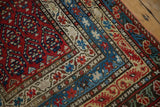 Corner detail of an antique Karabagh rug runner showing intricate tiered borders and recessed dark wool pile.