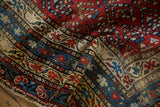 Recessed dark pile accentuates the floral and vine motifs in the rug's tiered borders.