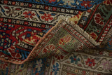 Detail of the antique Karabagh rug's hand-knotted foundation, colorful pile, and intact side selvage.