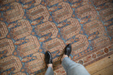 Detailed view of a vintage distressed Afshar carpet with alternating geometric botehs in blue and rust.