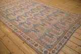 Angled perspective of a distressed Afshar carpet with terracotta and blue geometric botehs.
