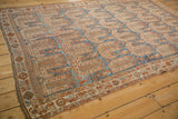 Intricate geometric border and low-pile texture of a vintage Persian Afshar carpet at an angle.
