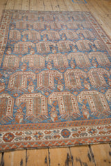 Angled view down the length of a distressed Afshar rug, highlighting its geometric pattern.