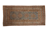Distressed Malayer rug runner with a column of terracotta diamond medallions on a worn, abrashed blue ground.