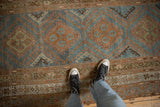 Geometric diamond medallions with hook and latch details on the abrashed blue ground of a Malayer runner.
