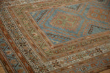 Angled view of a Malayer runner's short pile and geometric borders in blue and terracotta.