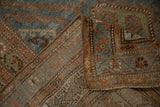 Folded corner of a Malayer rug revealing its dense, hand-knotted foundation and side selvage.