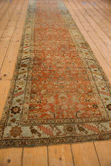 Distressed vintage Bijar rug with terracotta Herati field and pale blue vine border detail.