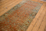 Distressed Persian Bijar runner's Herati pattern and floral border in terracotta, blue, gold.