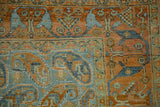 Close-up of the terracotta arabesque border and dusty blue boteh field on a distressed Afshar rug.