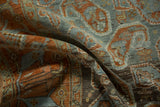 Folded view of a distressed Afshar rug showing its textured pile and terracotta boteh pattern.
