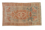 Vintage distressed Bijar rug featuring a red medallion and asymmetric design on a faded, dusty blue field.