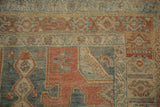 Corner detail of a vintage Bijar rug showing the even wear and geometric spandrel in dusty blue and red.