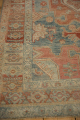 Corner detail of a vintage Bijar rug's spandrel and border in dusty blue and pomegranate red.