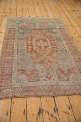 Vintage distressed Bijar rug from a low angle, highlighting its elongated medallion and faded palette.