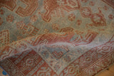 A folded corner of the distressed Bijar rug reveals its dense, hand-knotted pile and texture.