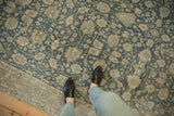 Low-pile texture of a vintage Bijar carpet in dusty navy with sand floral motifs.