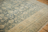 Time-softened texture and heavy abrash across the floral field and sand border of a distressed Persian rug.