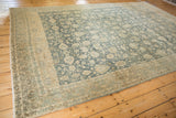 A vintage Persian Bijar carpet with noticeable abrash creating color shifts in the floral field.
