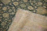 Corner of a vintage Bijar carpet folded over, showing its hand-knotted back and distressed floral pile.
