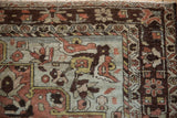 Close-up on the distressed texture and charcoal brown border of a vintage Persian Hamadan rug.
