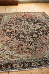 A low angle highlights the distressed texture and sprawling medallion of a vintage Hamadan carpet.