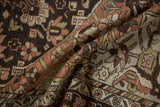 A folded view of the distressed Hamadan carpet, showing its even wear and hand-knotted texture.